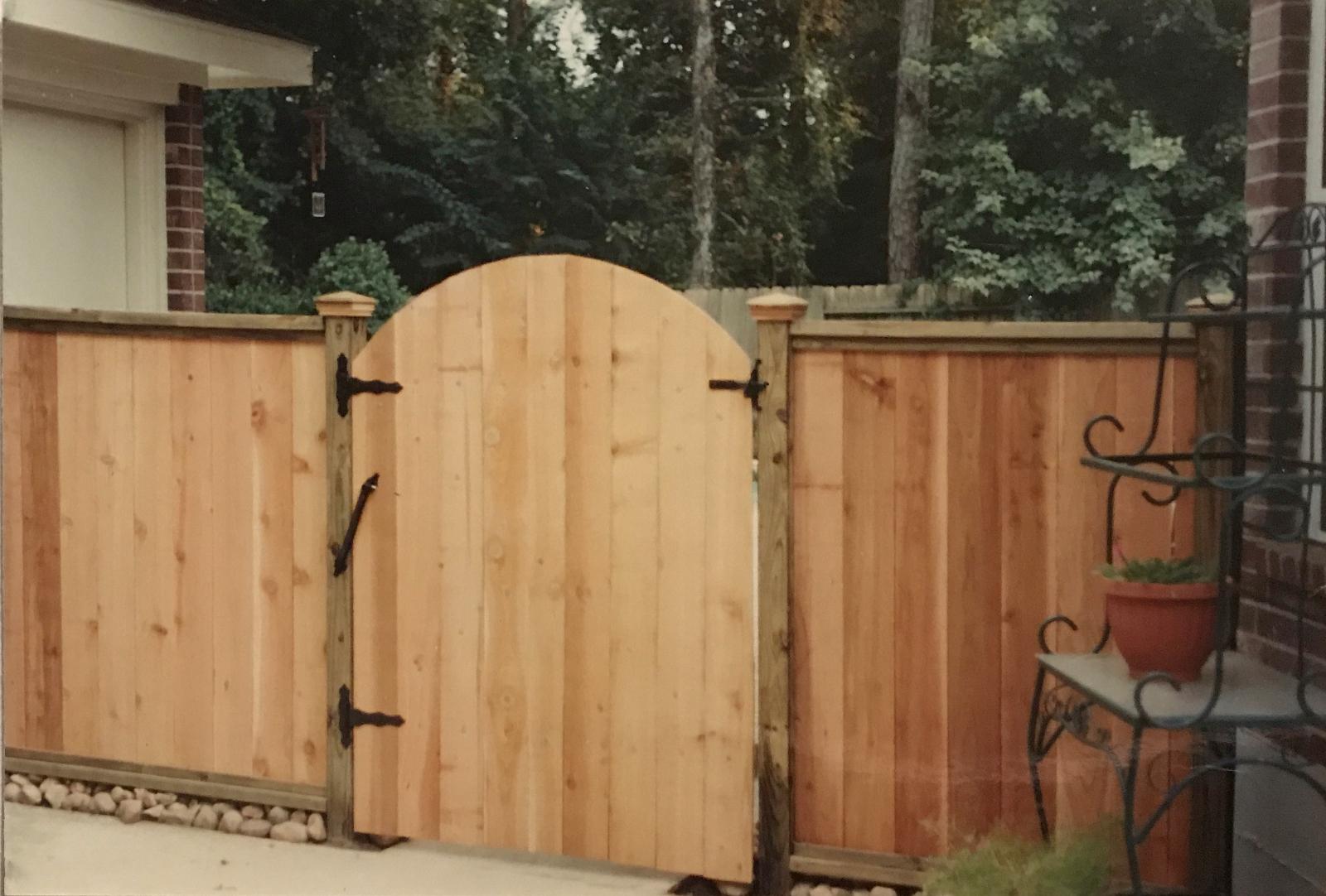 Arched cedar walk gate with iron hardware