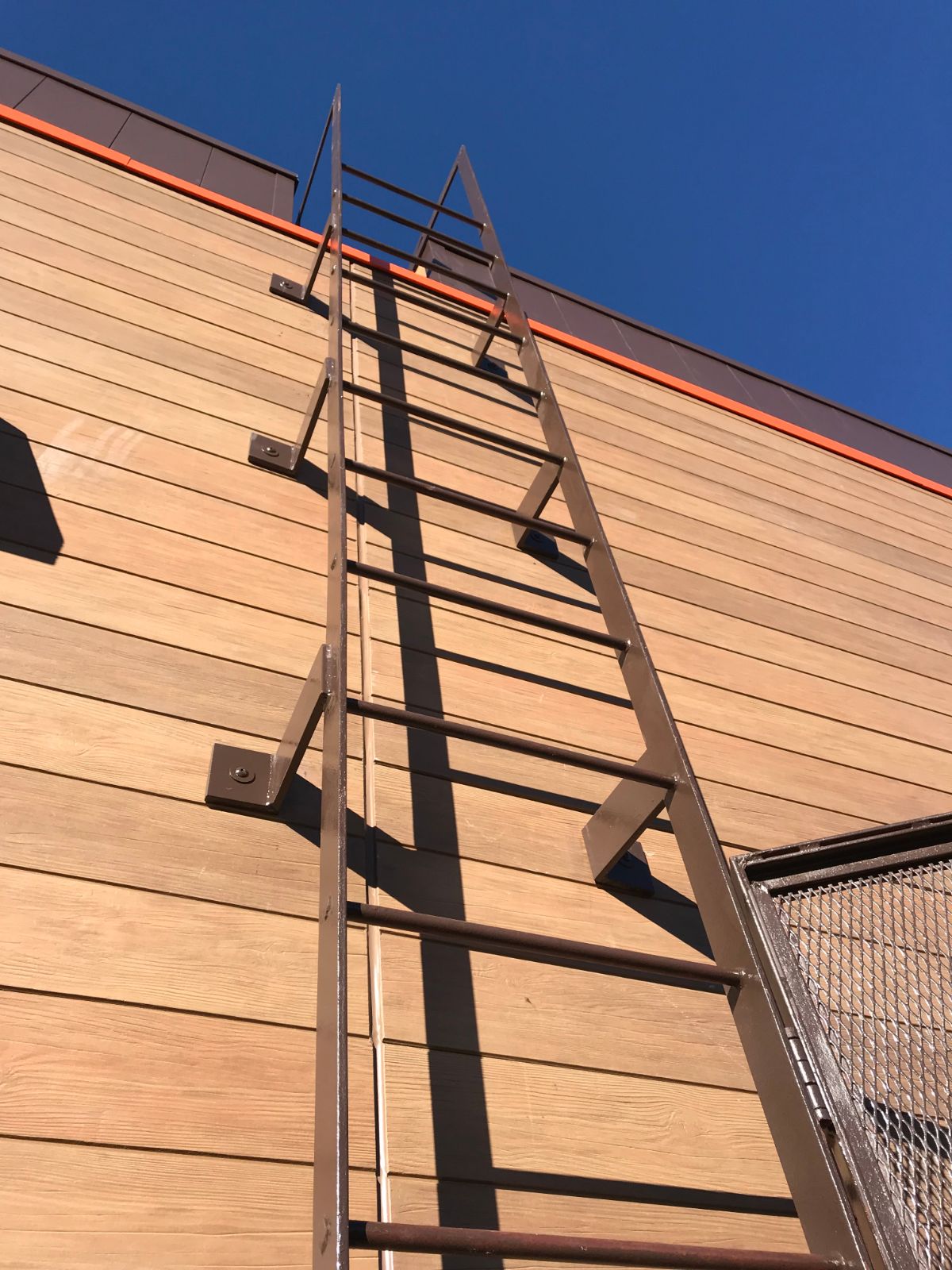 Wall-mounted steel roof access ladder on building at Bojangles Jefferson NC