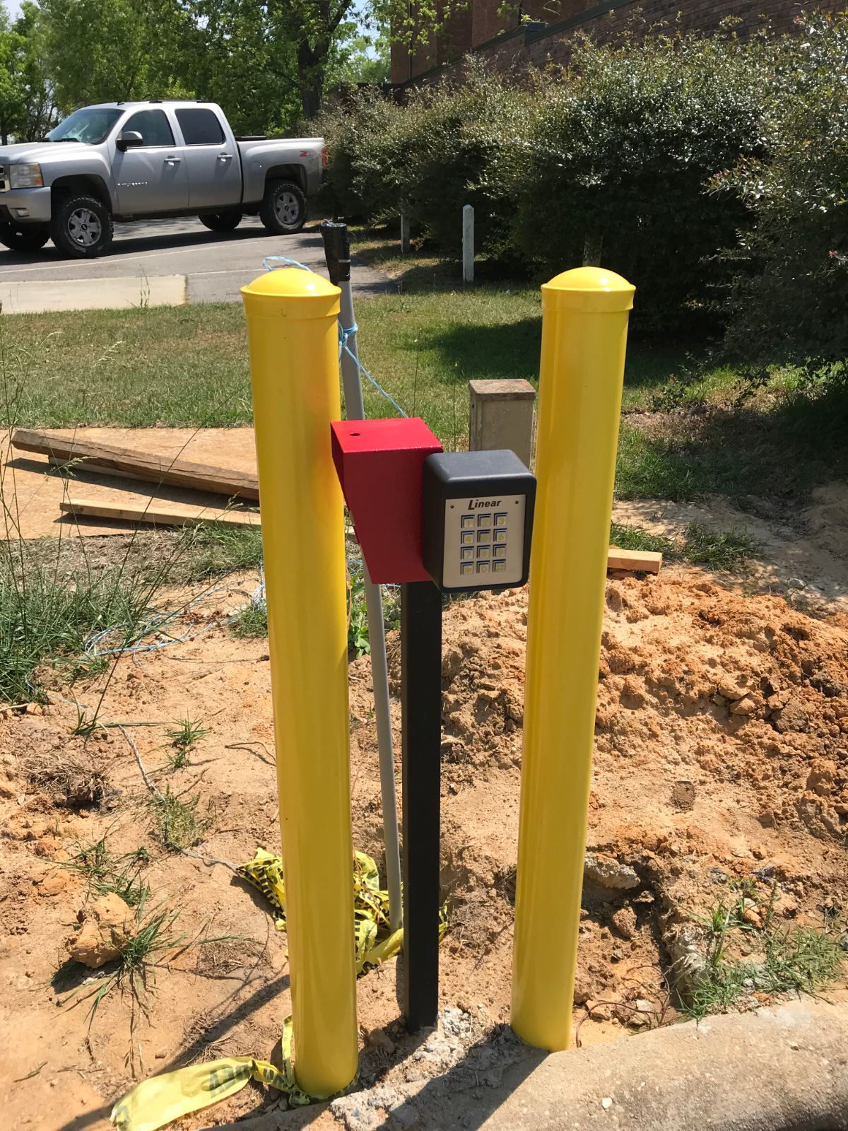 Keypad access control and 911 emergency box between yellow bollards