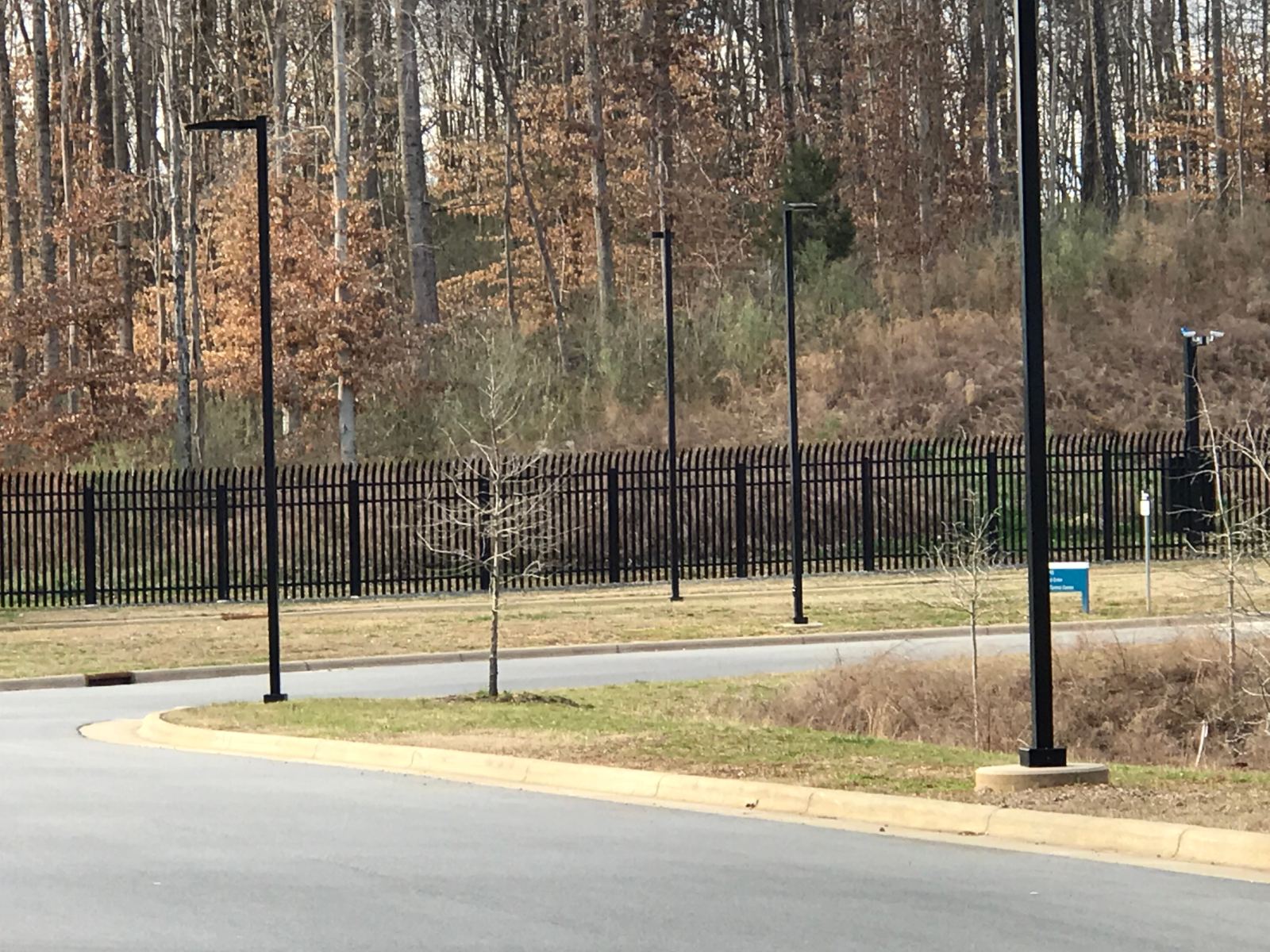 Black ornamental steel perimeter security fence along roadway at Duke Energy facility, Charlotte NC
