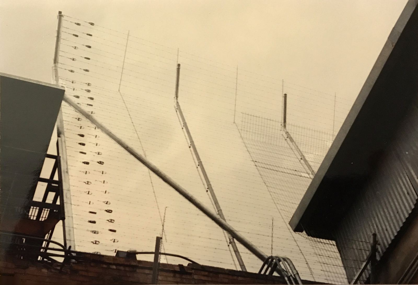 Angled electric security fence wires atop Huntsville Walls Unit wall