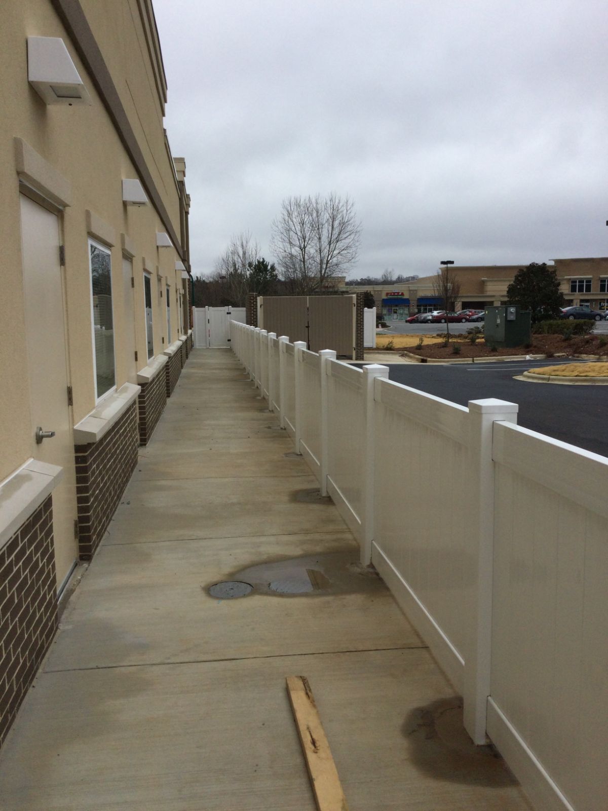4-foot white PVC fence core-drilled into sidewalk at The Learning Experience