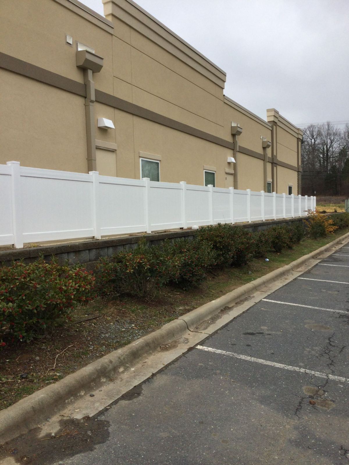6' High White PVC Fence Along Retaining Wall