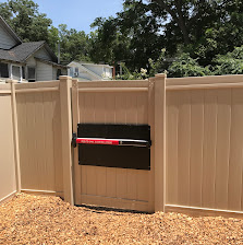 Tan vinyl fence with mailbox gate
