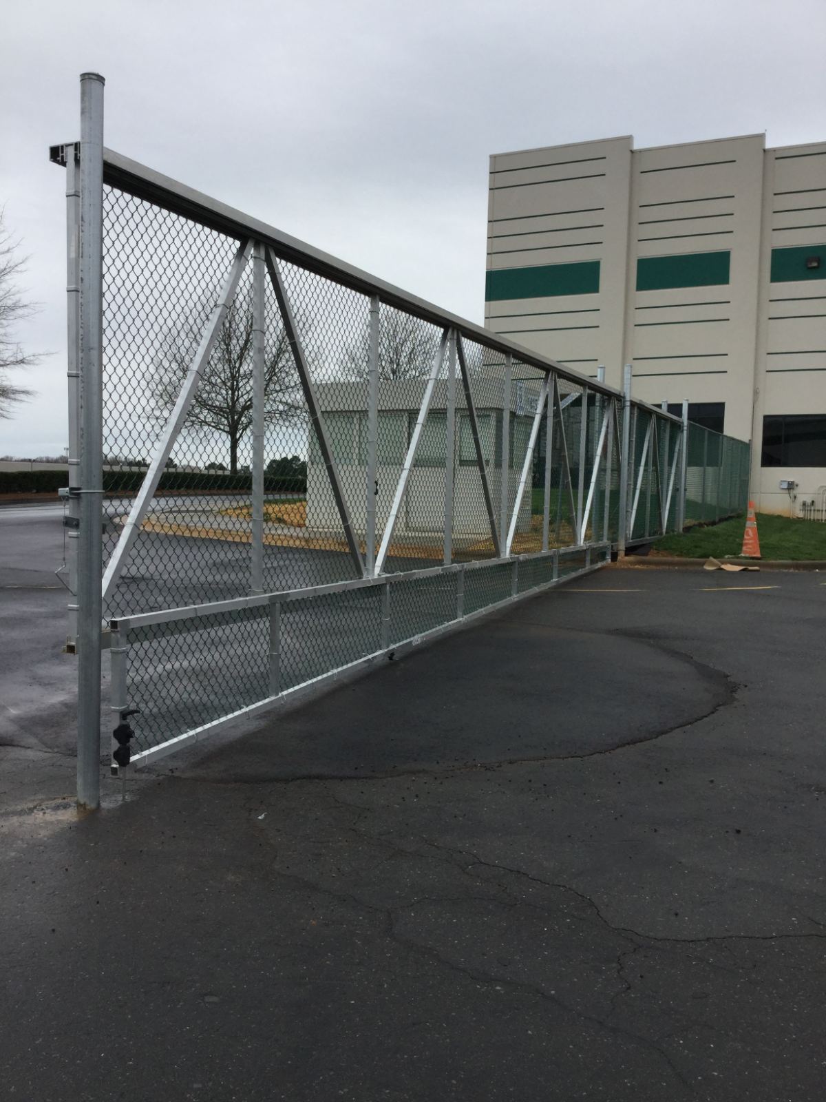 8-foot high aluminum sliding cantilever gate with folding panels on the bottom securing UPS facility