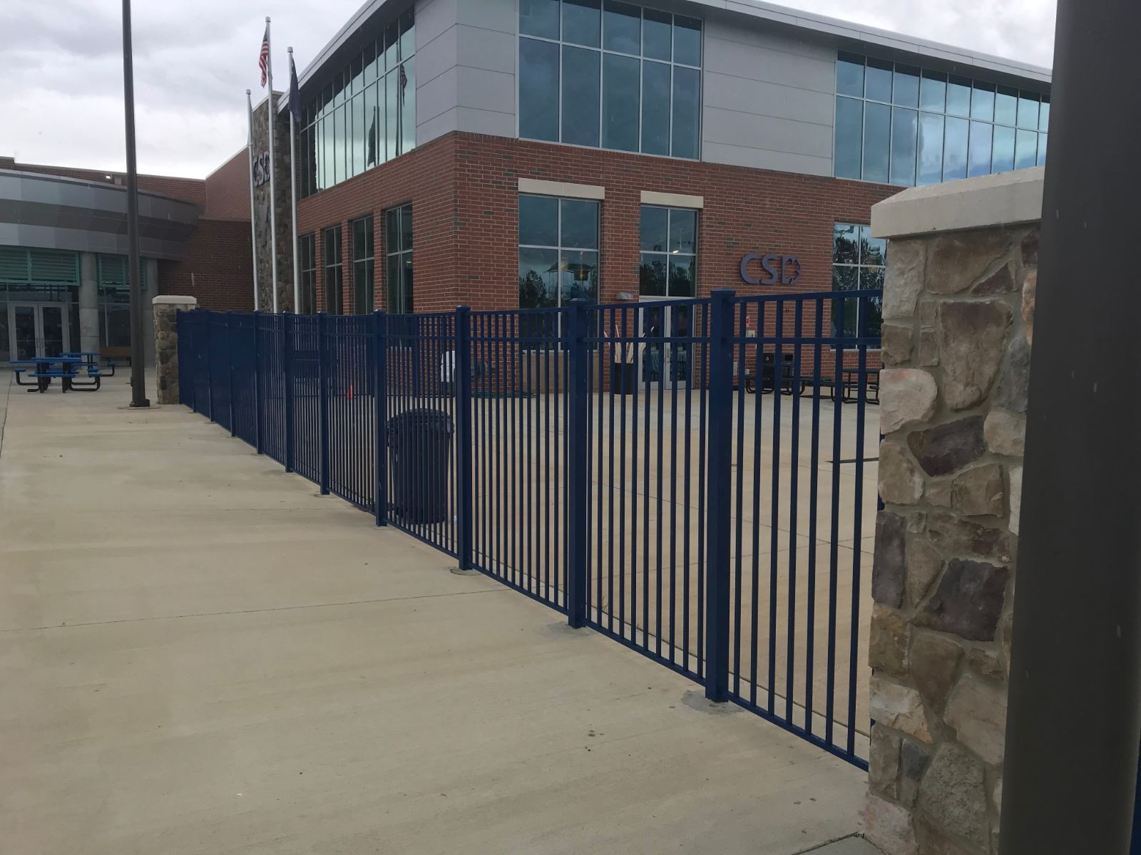 6-foot high blue aluminum fence along building entrance at YMCA Clover Lake Wylie Aquatics Center